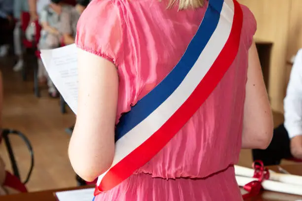 Photo of French blonde woman mayor with scarf france flag tricolor and girl pink dress during official celebration in city hall France