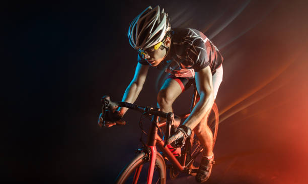 スポーツ。暗い背景のシルエットのアスリートサイクリスト - cycling shorts ストックフォトと画像