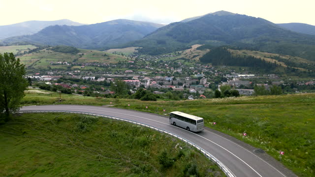 aerial view of bus moving by mountain road