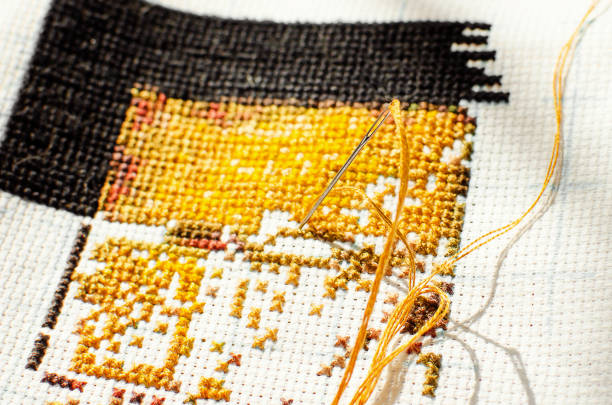 istock Cross-stitch. Yellow thread and a needle. Hobby, handmade home decor concept. 1333335442