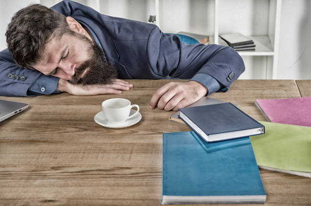 istock let me relax. Man sleeping over workplace. coffee will help me. bored and exhausted guy sleep at work. need break for relax. being lazy. Tired businessman sleep in office. boss fell asleep on table 1333337574