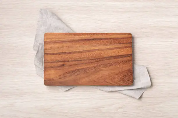 Wood cutting board on linen napkin, top view