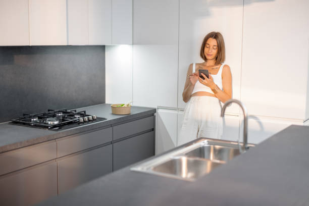 istock Woman with phone on the modern kitchen at home 1333338742