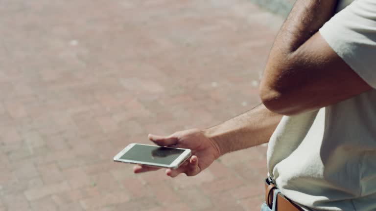 4k video footage of a handsome young man picking up his cracked cellphone after dropping it outside