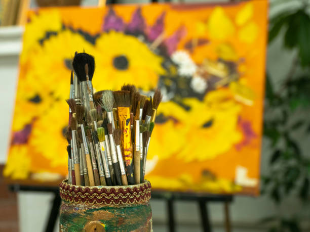istock Art brushes in a cup holder on a colored yellow background. 1333341344