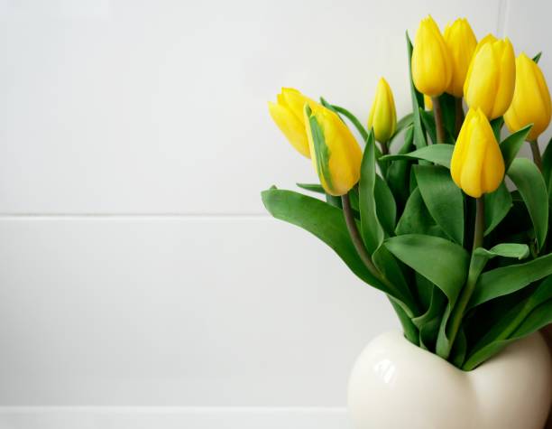 バスルームに白い花瓶の黄色い花束 - wearing flowers ストックフォトと画像