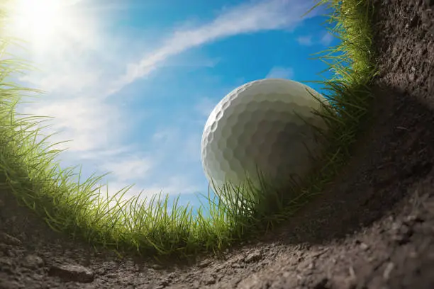 Photo of Golf ball is falling into hole. View from inside of hole. 3D rendered illustration.