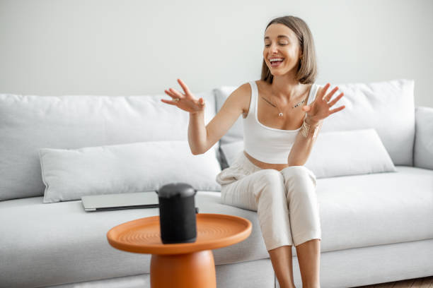 istock Woman managing home devices with a voice commands 1333346271