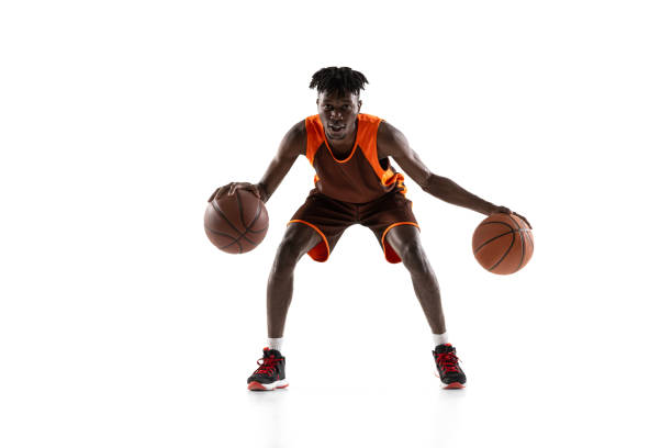 istock Young african man, basketball player in motion with two balls isolated over white studio background. Front view 1333346363
