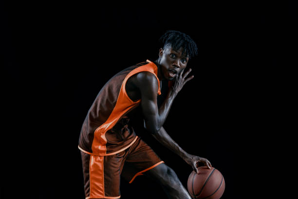 istock Professional african basketball player practicing with ball isolated over dark studio background. 1333346398