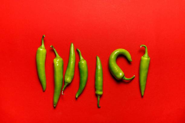 Green chili pepper pods on a red background, top view, horizontally, with space stock photo