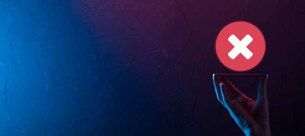 istock Hand holds icon,cancellation symbol,cancel icon.Cross mark flat red icon.round X mark.cancel button.Wrong.cross mark rejection.Declined.On dark background.Banner.Copy space.Place for text. 1333348809