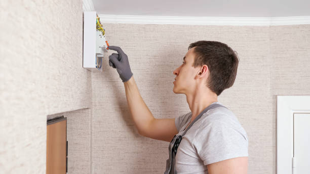 istock Electrician presses levers on switchboard to fix in room 1333349735