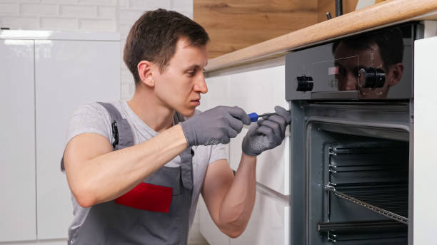 istock Craftsman twists screws on oven to find defect in kitchen 1333349743
