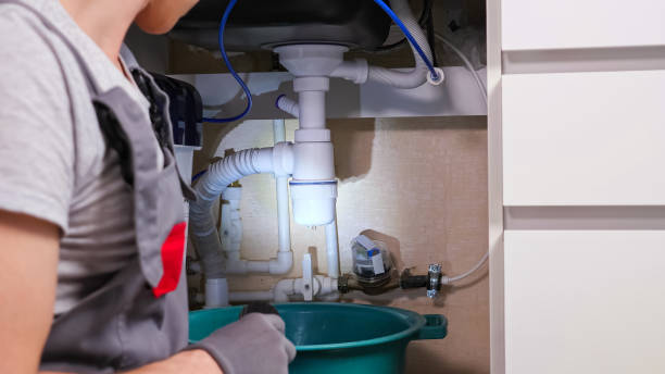 istock Man flashes torch looking at water leaking from waste trap 1333349745