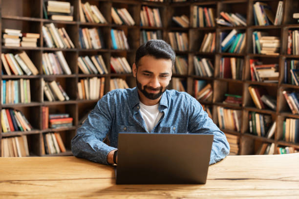 istock Confident concentrated indian freelancer guy working on laptop at home office 1333350025