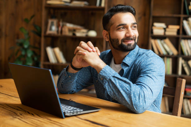 istock Happy and optimistic Indian man in casual wear using laptop 1333350175