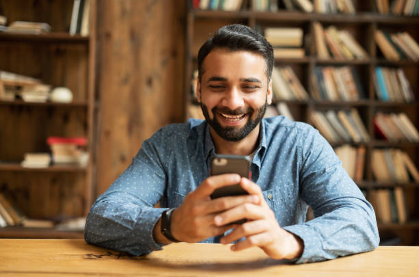 istock Young handsome Indian freelancer man using smartphone for online chatting 1333350405
