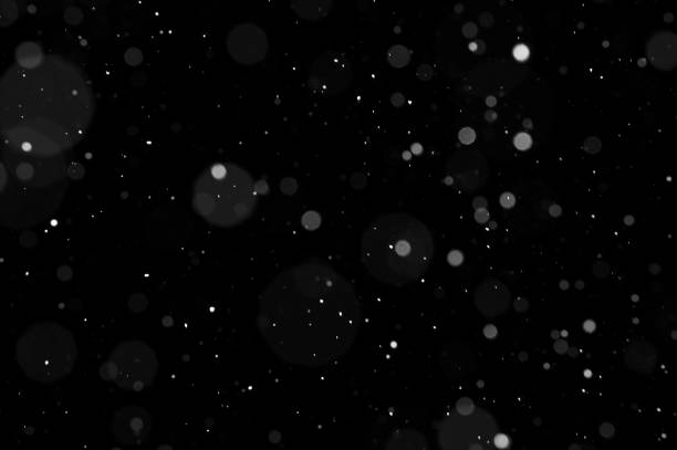 istock Bokeh of white snow on a black background. Snowfall - design element. 1333351096