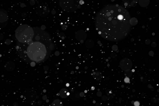 istock Bokeh of white snow on a black background. Snowfall - design element. 1333351218