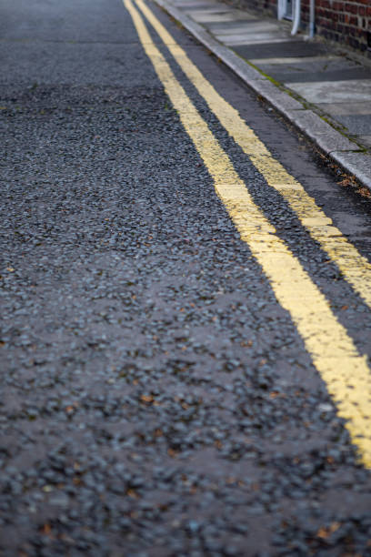 istock Double yellow lines painted on a residential road next to a pavement 1333352297