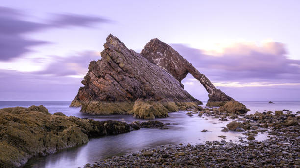 der bow fiddle rock zum sonnenuntergang in portknockie in schottland - water rock landscape cliff stock-fotos und bilder
