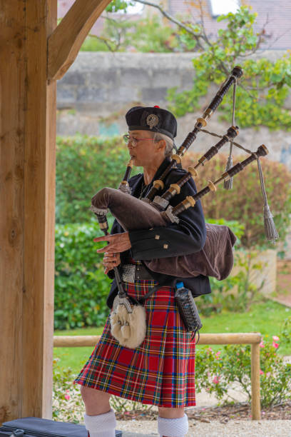 Langrune-Sur-Mer, France - 08 05 2021: Auld Alliance Pipe Band Langrune-Sur-Mer, France - 08 05 2021: Auld Alliance Pipe Band: Detail of the costume and instrument of a bagpiper tank musician stock pictures, royalty-free photos & images