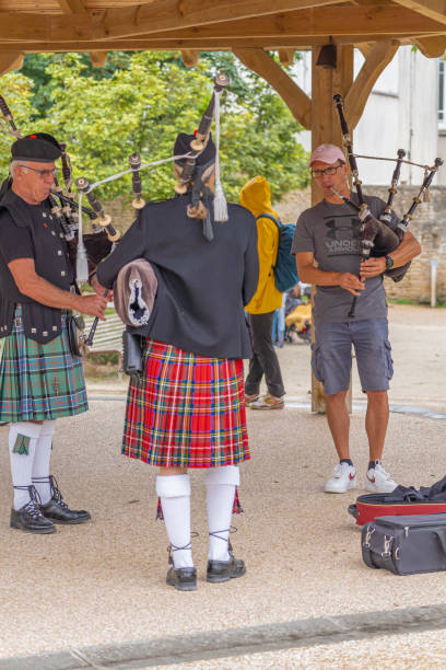 Langrune-Sur-Mer, France - 08 05 2021: Auld Alliance Pipe Band Langrune-Sur-Mer, France - 08 05 2021: Auld Alliance Pipe Band: Detail of the costume and instrument of a bagpiper tank musician stock pictures, royalty-free photos & images