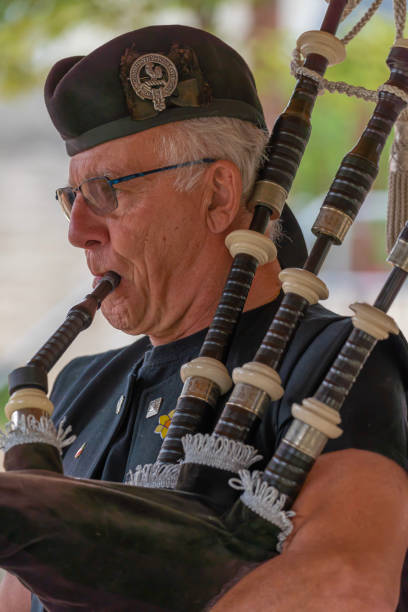 Langrune-Sur-Mer, France - 08 05 2021: Auld Alliance Pipe Band Langrune-Sur-Mer, France - 08 05 2021: Auld Alliance Pipe Band: Detail of the costume and instrument of a bagpiper tank musician stock pictures, royalty-free photos & images