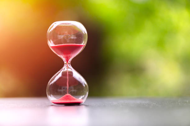 istock Hourglass against a green background 1333354095