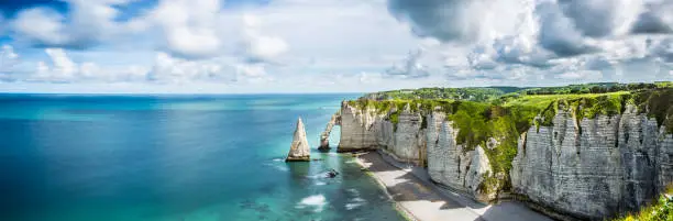 Beautiful sea beach Panorama in Etretat coast normandy. Atlantic ocean cliffs rocks in France. Famous coastline in europe.