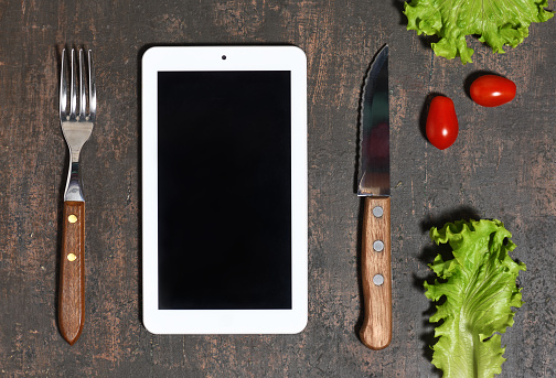 Tablet mock up with food ingredients on wooden background