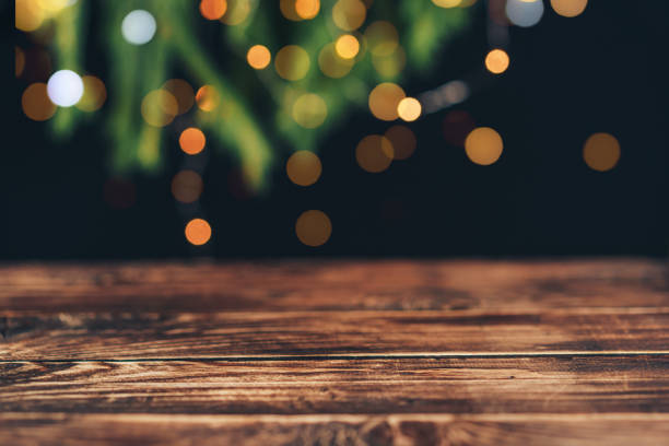 istock Empty wooden table in front of christmas tree branches with garland 1333356570