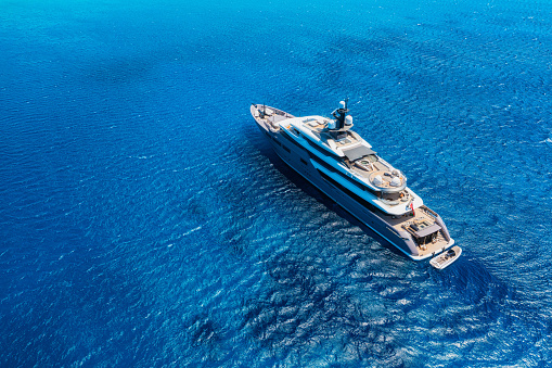 Aerial view of the ship from drone. Blue clear water in the Mediterranean Sea. Summer vacation and travel on a cruise liner. Summer trip.