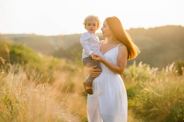 istock Mom holds a cute son in her arms while walking in nature 1333357907