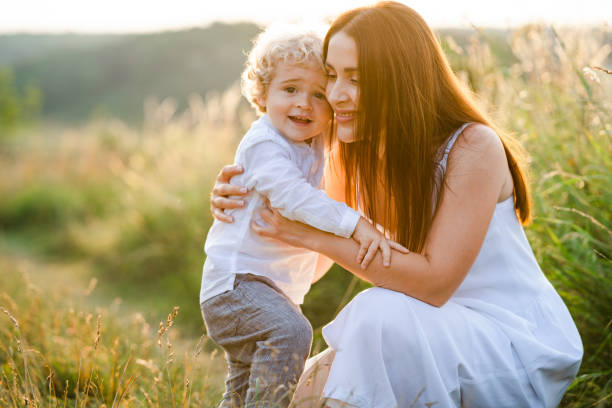 istock Mother hugs her curly son in nature 1333357984