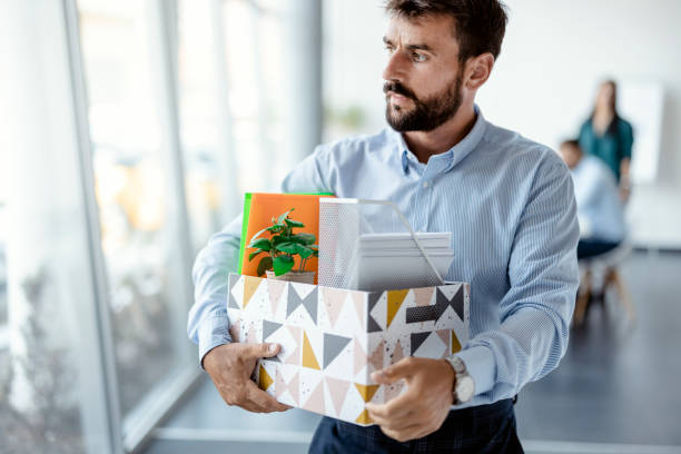 Leaving the office Business, Firing and Job Loss Concept - Sad Fired Male Office Worker With Box of His Personal Stuff being fired stock pictures, royalty-free photos & images