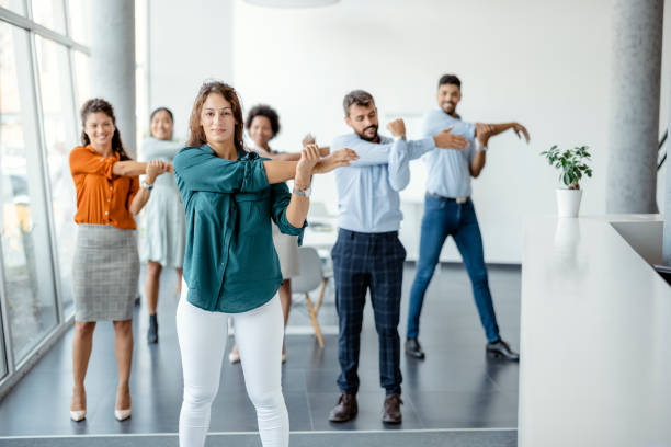 empresarios haciendo ejercicio de estiramiento en el lugar de trabajo - break office 30s 20s fotografías e imágenes de stock