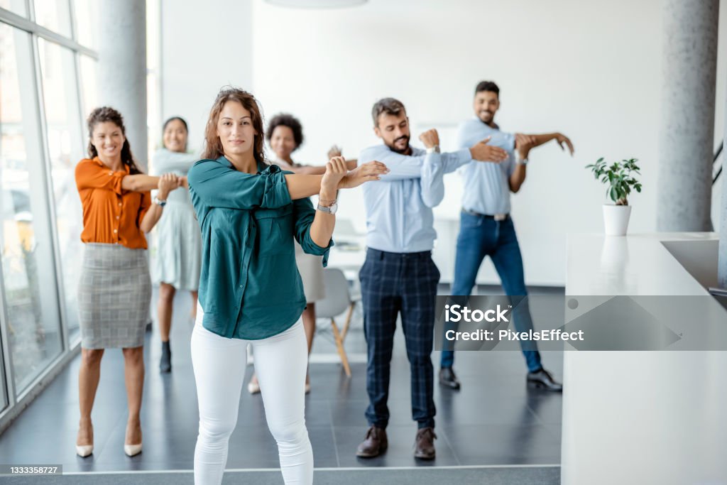 Businesspeople Doing Stretching Exercise At Workplace Stretch Exercise Business Group Workout In Office Office Stock Photo