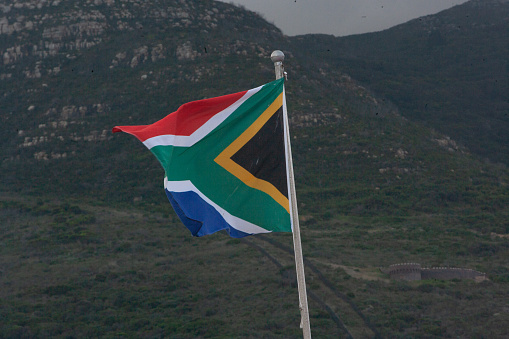 A series of pictures of the post-Apartheid South African flag billowing in the wind on the backdrop of a dark and moody sky with characteristic ZA colours of green, yellow, black, white and red