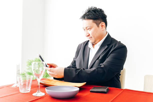 istock Middle-aged man paying with smartphone at restaurant 1333360011