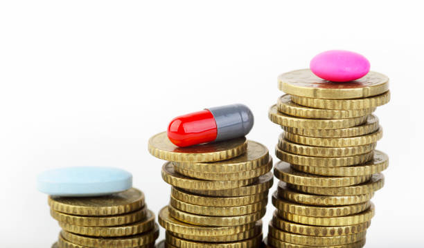 стопка монет и таблеток. концепция роста расходов на здравоохранение - vitamin pill capsule equipment data стоковые фото и изображения