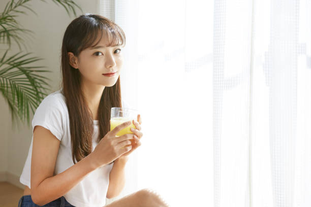 istock A young Asian woman drinking a fruit juice 1333363608