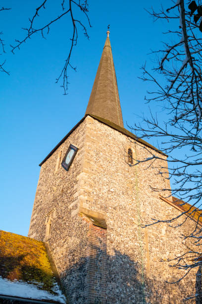 Church of St Martin in Eynsford, England The history of this church goes back to William of Normandy who conquered England in 1066 and became king. He rewarded a Norman knight called Unspac who had fought with him by giving him the Eynsford land. Unspac's son Ralf built St Martin's Church on the site of an old Saxon church, using local Kentish flint. Ralf renamed himself William d'Eynsford in honour of William the Conqueror. norman uk tree sunlight stock pictures, royalty-free photos & images