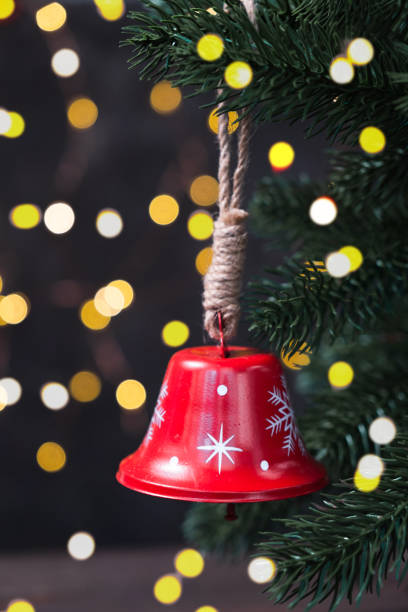 istock Christmas composition with a red bell on fir tree on background garland lights. 1333367465