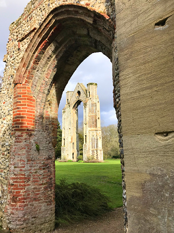 All that remains of the Walsingham Priory Church in Norfolk England. Once the most important pilgrimage location  to the Virgin Mary in the land, the shrine was destroyed at the Reformation in 1538 by King HenryVIII.The east window ruin is now  all there is to see of the venerable buildings, but still, this east window arch in its splendid isolation gives some idea of the size of the shrine which was visited by faithful catholics from across England and the continent.Known as Englands \