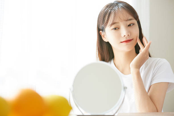 una joven asiática cuidando la piel - beauty treatment fotos fotografías e imágenes de stock
