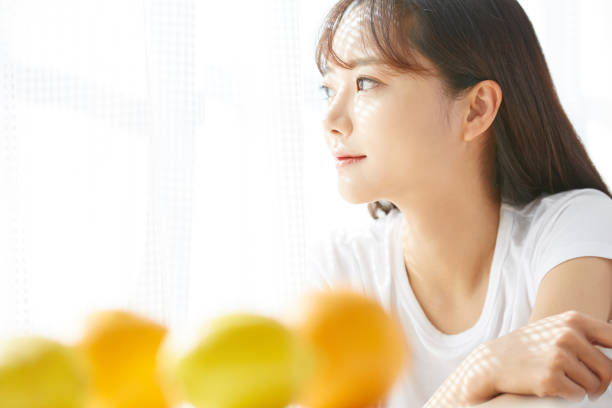 果物を持つ若いアジアの女性の肖像 - 健康と美容 ストックフォトと画像