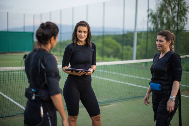 istock Two women talking with their personal trainer after effective workout in electro muscle stimulation suit outdoors 1333370023