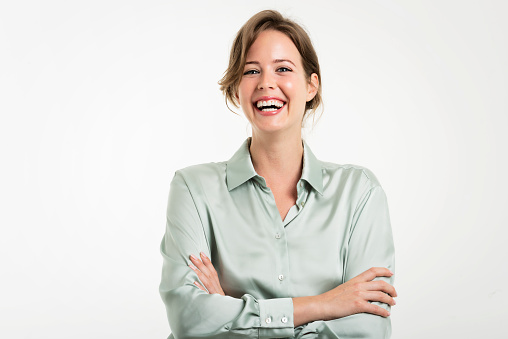 Studio portrait of attractive business woman standing with arms crossed at isolated white background. Copy space.